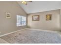 Bright bedroom featuring neutral walls and flooring, large windows, modern ceiling fan and a patterned area rug at 7720 Leavorite Dr, Las Vegas, NV 89128