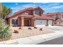 Charming two-story home featuring a three-car garage and a low-maintenance front yard with rock landscaping at 7720 Leavorite Dr, Las Vegas, NV 89128