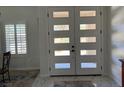 Modern front door with glass panels and views of a home interior with marble flooring at 871 Buol Rd, Pahrump, NV 89048