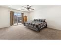 Bright bedroom with a ceiling fan, balcony access, and a cozy plaid bedspread at 9268 Wildfire Gorge St, Las Vegas, NV 89139