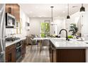 Open kitchen boasts stainless steel appliances, stylish lighting, and eat-in dining space at 11756 Emerald Lake Ave, Las Vegas, NV 89138