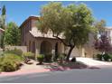 Exterior elevation of two-story home featuring desert landscaping and arched entry at 11832 Arenoso Dr, Las Vegas, NV 89138
