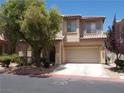 Attractive two-story home with tile roof, arched entry, a two-car garage, and desert landscaping at 11832 Arenoso Dr, Las Vegas, NV 89138