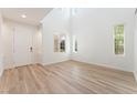 Bright, airy living room featuring high ceilings, wood-look floors, and multiple windows for abundant natural light at 11900 Calle De Sol Dr, Las Vegas, NV 89138