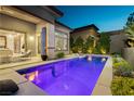 Private backyard pool with lush landscaping and access to interior living spaces at 12382 Tudor Arch Dr, Las Vegas, NV 89138