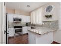 Modern kitchen featuring white cabinetry, granite countertops, and stainless steel appliances at 1839 Thunder Mountain Dr, Henderson, NV 89012