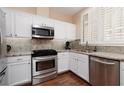 Well-equipped kitchen with granite counters, stainless steel appliances, and white cabinets at 1839 Thunder Mountain Dr, Henderson, NV 89012