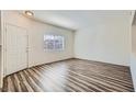 Bright living room featuring wood-look floors, neutral walls, and a front door entrance at 1881 W Alexander Rd # 1092, North Las Vegas, NV 89032