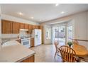 Cozy kitchen and dining area featuring tile floors, a gas range, and sliding glass doors to the backyard at 2535 Leighton Ave, Henderson, NV 89052