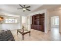 Bright living room with tile floors, ceiling fan, and a large built-in bookcase with ample storage at 2535 Leighton Ave, Henderson, NV 89052