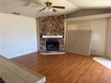 Cozy living room featuring a stone fireplace and hardwood floors at 3090 N Woodchips Rd, Pahrump, NV 89060