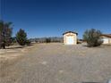 Expansive lot featuring a detached garage/workshop and desert landscaping at 3090 N Woodchips Rd, Pahrump, NV 89060