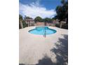 Community pool with clear blue water, surrounding patio, and security fencing at 4238 Rollingstone Dr, Las Vegas, NV 89103