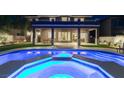 Backyard with a refreshing pool, spa, covered patio, and lush green lawn at 5573 San Florentine Ave, Las Vegas, NV 89141