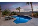 A serene pool with a spa is flanked by palm trees and lounge chairs against a sunset backdrop at 6245 Galileo Dr, Las Vegas, NV 89149