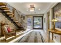 Inviting foyer with a floating staircase and a decorative rug on light hardwood flooring at 6570 Aurora View St, Las Vegas, NV 89135