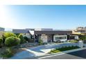 Beautiful modern home with distinct architectural lines, complemented by lush landscaping and mature trees at 671 Scenic Rim Dr, Henderson, NV 89012