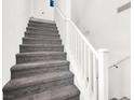 Carpeted stairs with white railing lead to the upper level of this home at 8949 Merry Mullion Ct, Las Vegas, NV 89149