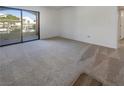 Spacious carpeted living room with sliding glass door and access to outdoor balcony with lots of natural light at 950 Seven Hills Dr # 217, Henderson, NV 89052