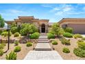 Paver steps lead to the front entrance, which is beautifully landscaped with desert foliage at 9747 Cathedral Pines Ave, Las Vegas, NV 89149