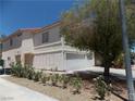The side of this two story home has a two-car garage and desert landscaping at 1018 Sun Poppy Ave, Las Vegas, NV 89123