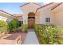 Inviting home entrance with elegant double doors, desert landscaping, and a charming walkway at 10548 Findlay Ave, Las Vegas, NV 89134