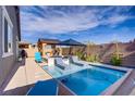 Inviting backyard pool with lounge chairs, umbrella, and shaded seating area at 129 Barton Bay Ave, North Las Vegas, NV 89031