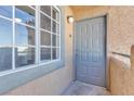 Close-up of the unit entrance with a gray front door and window, providing a secure and private entry at 220 Mission Catalina Ln # 208, Las Vegas, NV 89107