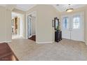 Open foyer with double doors, neutral tile flooring and dark wood accents at 2899 Brook Trout Ct, Henderson, NV 89052