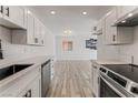 Well-lit kitchen with white cabinets, modern countertops, stainless steel appliances, and wood flooring at 2915 Cedar Ave # 12C, Las Vegas, NV 89101