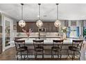Stunning kitchen island featuring white countertop, a sink, dark cabinets, and four comfortable chairs at 3 Vicolo Sebino, Henderson, NV 89011
