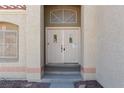 Close-up showcasing the double front doors with a decorative window above, set in a stucco exterior at 426 Lost Trail Dr, Henderson, NV 89014