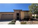 Inviting home with stone accents, desert landscaping, wrought iron gate, and two-car garage at 4732 S Adriano Way, Pahrump, NV 89061