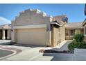 Tan home featuring a two-car garage, beautiful landscaping, and close up view of home number at 4841 Raw Umber Ct, Las Vegas, NV 89131