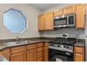The kitchen showcases stainless steel appliances, wood cabinetry, and granite countertops at 5042 S Rainbow Blvd # 206, Las Vegas, NV 89118