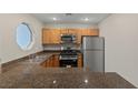 The kitchen showcases stainless steel appliances, wood cabinetry, and granite countertops at 5042 S Rainbow Blvd # 206, Las Vegas, NV 89118