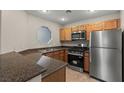 The kitchen showcases stainless steel appliances, wood cabinetry, and granite countertops at 5042 S Rainbow Blvd # 206, Las Vegas, NV 89118