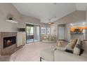 Inviting living room featuring a cozy fireplace, plush carpet, and sliding glass doors to a private balcony at 5042 S Rainbow Blvd # 206, Las Vegas, NV 89118