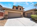 Home features a large driveway with a three-car garage and stone veneer accents at 5568 Table Top Ln, Las Vegas, NV 89135