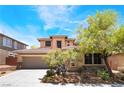Two-story house featuring well-maintained landscaping, desert plants, a large driveway, and a two-car garage at 5568 Table Top Ln, Las Vegas, NV 89135