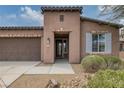 Close-up of the front entry featuring a decorative door, desert landscaping, and brick accents at 5625 Galivan Vista St, North Las Vegas, NV 89081
