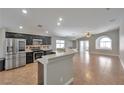 Open-concept kitchen with stainless steel appliances, dark cabinets, and views of the expansive living area at 5732 Hornbrook St, North Las Vegas, NV 89031