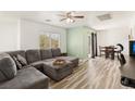 Spacious living room with a large sectional sofa, wood-style flooring, and a ceiling fan at 6313 Pangea Ave, Las Vegas, NV 89139