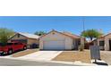 A front yard view of a single-story home with desert landscaping and a two-car garage at 6615 Elk Creek Ln, Las Vegas, NV 89156