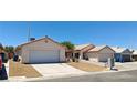 Street view of the home, featuring a driveway, desert landscaping, and an attached garage at 6615 Elk Creek Ln, Las Vegas, NV 89156