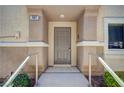 Welcoming front entrance featuring a contemporary door, railing, and manicured shrubbery at 8768 Tom Noon Ave # 101, Las Vegas, NV 89178