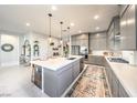 Stylish kitchen featuring a spacious island with seating and modern appliances with marble floors at 879 Klamath Springs St, Henderson, NV 89011