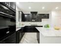 Modern kitchen featuring dark cabinetry, granite counters, an island, and stainless steel appliances at 12426 Mosticone Way, Las Vegas, NV 89141