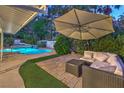 Inviting outdoor space boasting a covered patio with seating, lush greenery, and a tranquil poolside view at 2231 Marlboro Dr, Henderson, NV 89014
