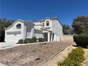 Charming two-story white home featuring desert landscaping, a two-car garage and well maintained perimeter walls at 3929 Dream St, Las Vegas, NV 89108